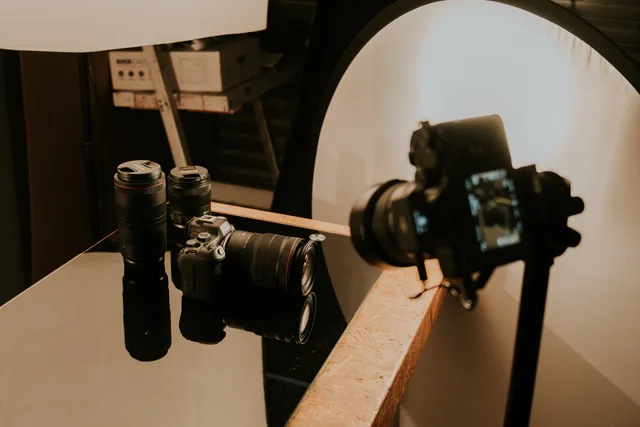 A detailed view of a professional camera setup with lenses and lighting in a studio environment. Keeping product colours consistent across shots