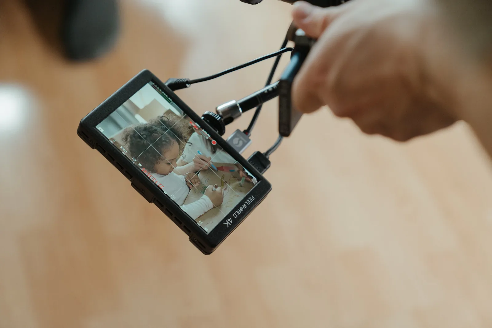 A camera monitor reveals a close-up shot of a child during filming, emphasizing creative processes.