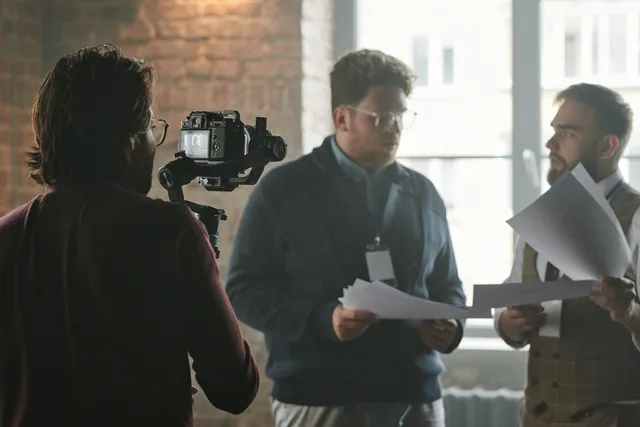 A professional team in a modern office setting being filmed during a business discussion. Planning a business video shoot
