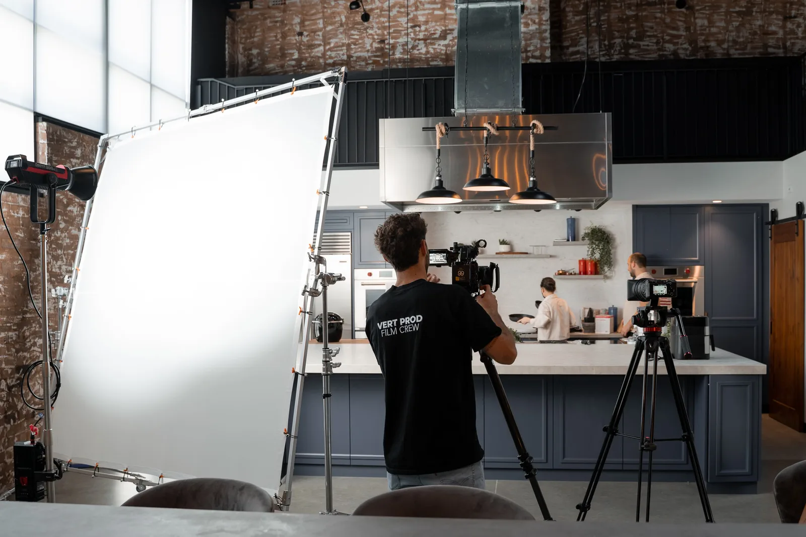 Explore a professional film crew capturing culinary art in a chic modern kitchen setup.